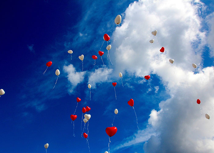 Palloncini bianchi e rossi che volano in cielo
